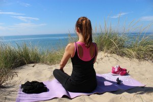 Frau meditiert am Strand