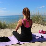 Frau meditiert am Strand