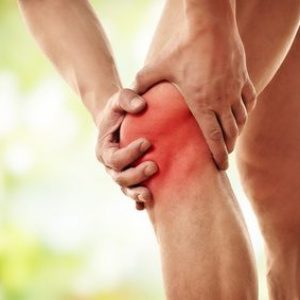 Mann hält sich schmerzendes Knie